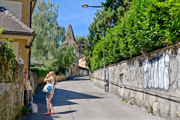 deux jeunes femmes prenant des photos sur une rue en neuchatel - railing beautiful human leg people photos et images de collection