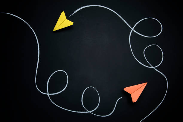 istock Two Paper Airplanes with Chalk Path Creative Idea on Black Chalkboard 1172377434