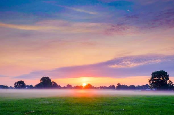 Colorful glowing sunrise over a countryside farming area, creating an idyllic scenic landscape