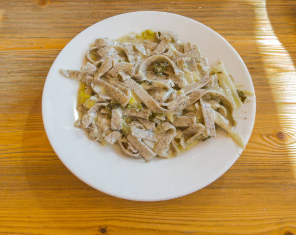 pizzoccheri sind ein traditionelles italienisches gericht aus dem valtellina. gericht zubereitet mit pasta ähnlich tagliatelle mit geschmolzenem käse, kohl und kartoffeln - pizzoccheri homemade tagliatelle italy stock-fotos und bilder