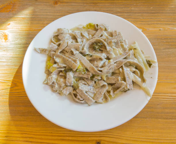 los pizzoccheri son un plato tradicional italiano de la zona de valtellina. plato preparado con pasta similar al tagliatelle con queso derretido, repollo y patatas - pizzoccheri homemade tagliatelle italy fotografías e imágenes de stock