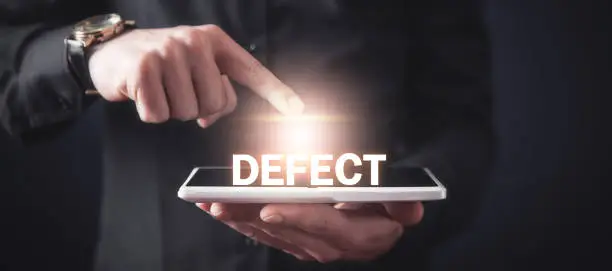 Photo of Man touching Defect word and using tablet computer.