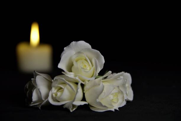 istock Guardian angel, Fir branches with a burning candle on black background. Christmas tree branches and an Angel lying on the table against darkness. 1172394213