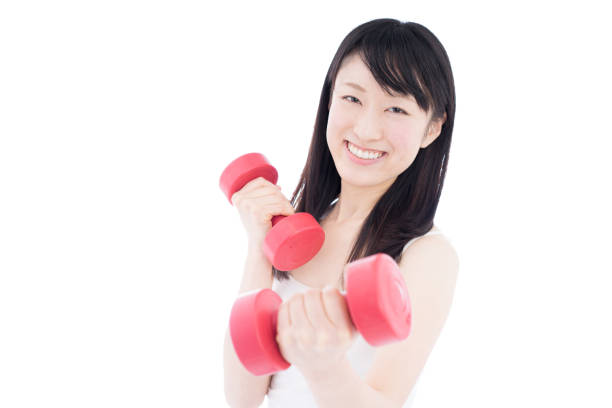 Young woman holding dumbbells isolated on white background.