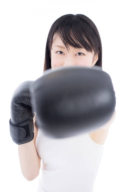 Young woman wearing boxing gloves Young woman wearing boxing gloves isolated on white background. boxercise stock pictures, royalty-free photos & images