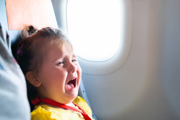 Girl Screaming On Airplane Little Girl Sitting Next To Mother Screaming On Airplane crying stock pictures, royalty-free photos & images