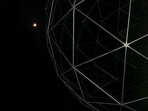 geodesic dome bones against the night sky with tiny moon