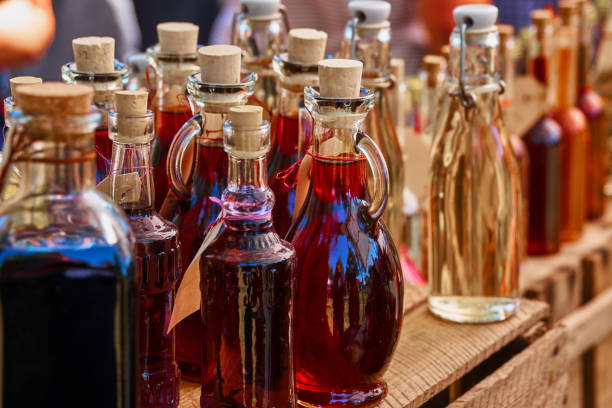 bottiglie di liquore fatto in casa e grappa su una mensola di legno - fruit liqueur foto e immagini stock