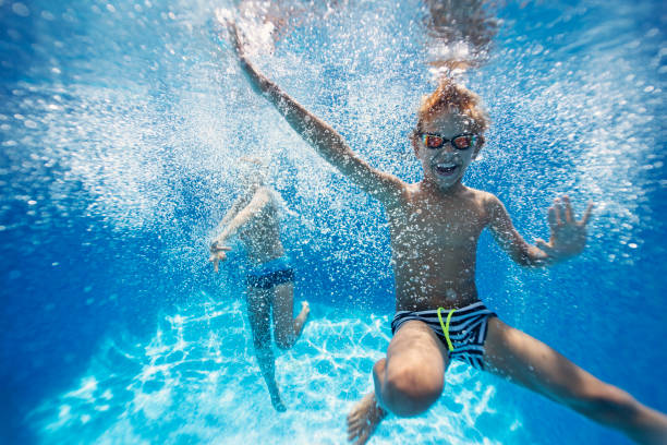 istock Happy kids having underwater party in pool 1172400810