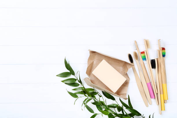 istock Bamboo toothbrushes with soap and green leafs on white wooden table 1172405063