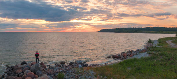 istock man at sunset by the sea. 1172405238