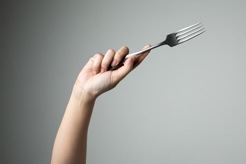 fork with hand on grey background utensil kitchen for cooking