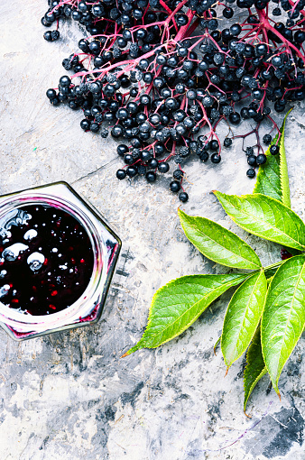 Homemade preserves of fresh elderberry in glass jarElderberry jam and fresh berries.Homemade jam.Space for text