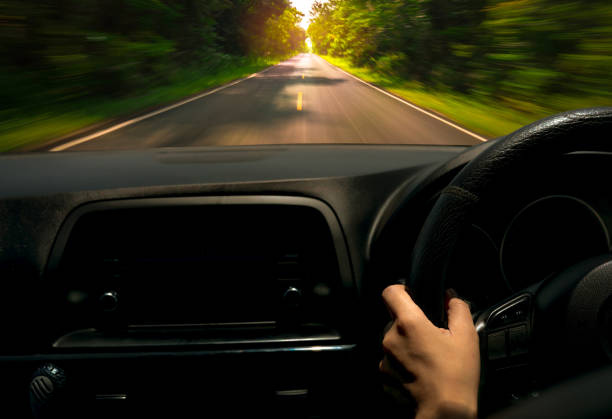 Driver hand holding steering wheel for control car. Inside view of car. Dashboard and windshield. Driving car on asphalt road with motion blur in the green forest. Perspective view fast car on highway conductor mano sosteniendo el volante para el coche de control. vista interior del coche. tablero y parabrisas. coche de conducción en carretera de asfalto con desenfoque de movimiento en el bosque verde. perspectiva vista coche rápido en la carretera