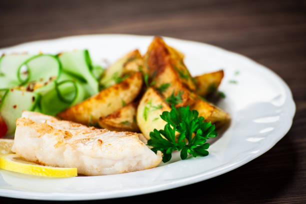 istock Fried cod fillet with baked potatoes and vegetables 1172421186