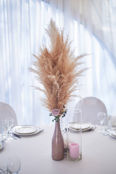 istock Wedding decoration in boho style.Light colors, in the tent. Wedding table decorated with a vase of pampas grass. Boho style 1172421290
