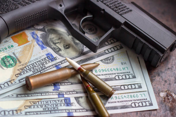 schwarze pistole und waffenkugeln auf us-dollar hintergrund. militärindustrie, krieg, globaler waffenhandel und verbrechenskonzept. - currency crime gun conflict stock-fotos und bilder