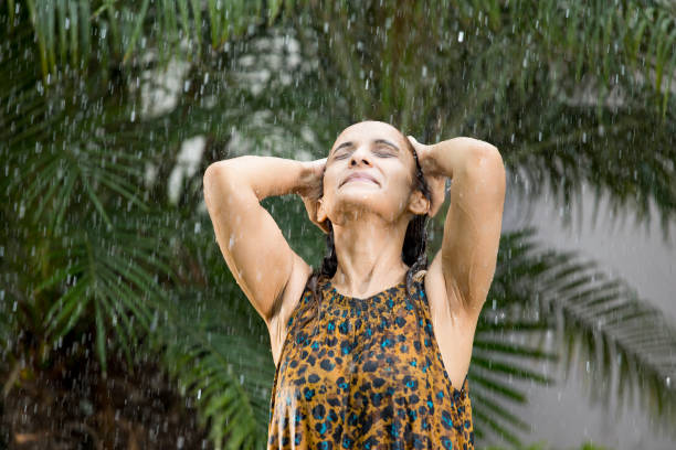 istock Indian woman enjoying rain 1172426108