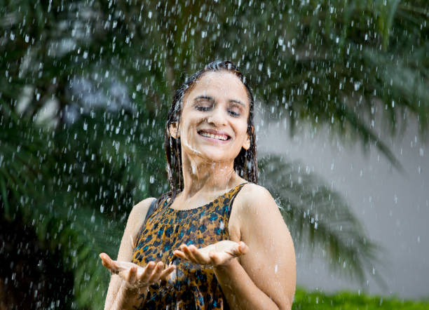 istock Indian woman enjoying rain 1172426153