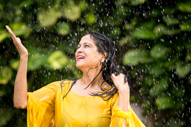 istock Indian woman enjoying rain 1172426323