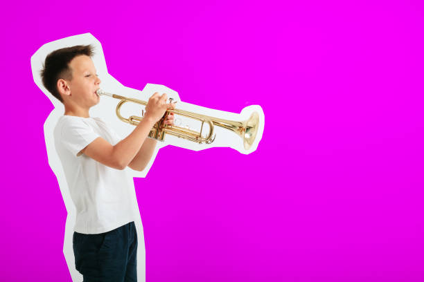 istock a child playing trumpet on turquoise background 1172428191
