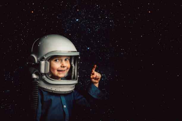 Small child wants to fly an airplane wearing an airplane helmet Small child wants to fly an airplane wearing an airplane helmet cosmonaut photos stock pictures, royalty-free photos & images