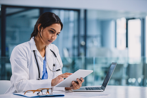 Shot of a young doctor using a digital tablet in a hospital