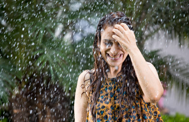 istock Indian woman enjoying rain 1172429560