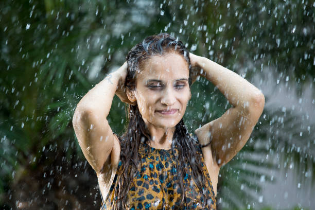 istock Indian woman enjoying rain 1172429707