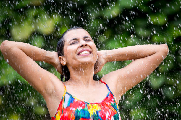 istock Indian woman enjoying rain 1172431424