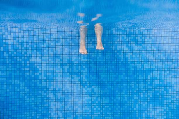 수영장에서 물 아래 이동 하는 사람들의 발. 어린이 다리. 여름. 수영장에서 재미 수중 다리, 여성이나 아이들의 물보기, 휴가 및 스포츠 개념에서. - underwater textured effect water textured 뉴스 사진 이미지