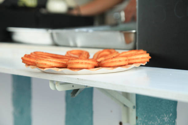 Several churros on a small plate on a table for breakfast.