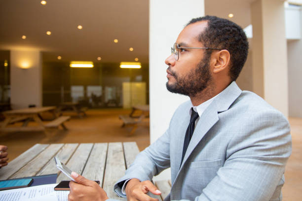 istock Pensive businessman holding digital gadget 1172436266
