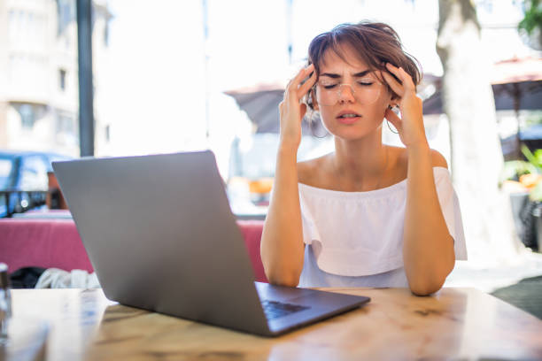 istock Young pretty woman with headache sitting at the table 1172437482