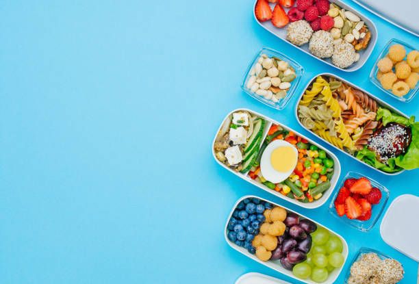 istock Pattern of lunch boxes filled with healthy food on blue background 1172438174