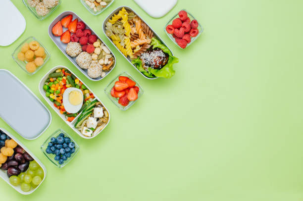 istock Plastic lunch boxes filled with healthy food on green background 1172438175