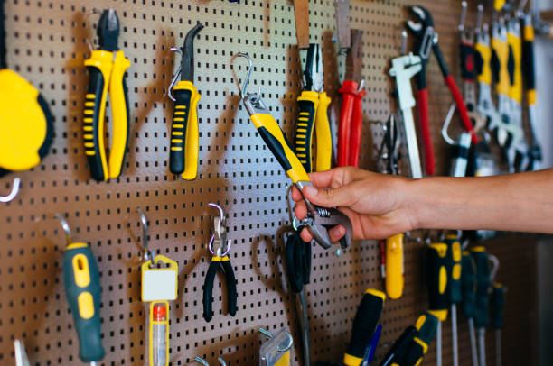 istock Male hand taking adjustable wrench from the lattice wall with different tools 1172438277