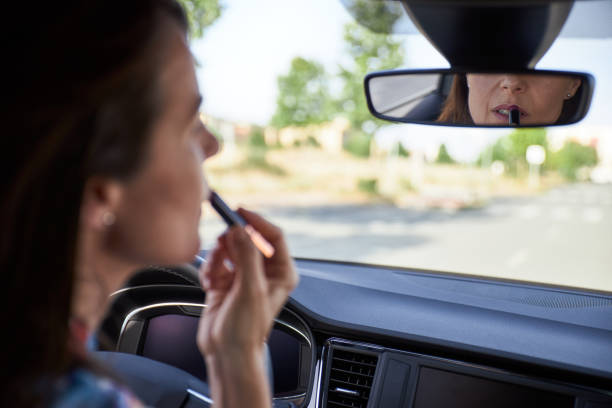 istock woman in her car while painting her lips 1172438801
