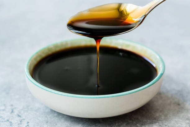 istock Organic Black Cane Sugar Molasses Dripping from Spoon 1172439704