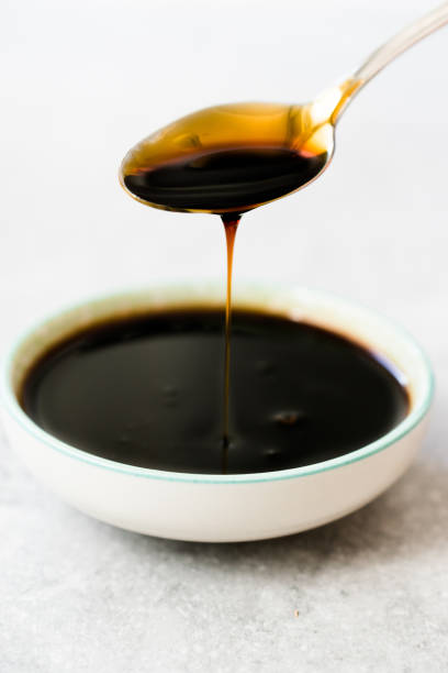 istock Organic Black Cane Sugar Molasses Dripping from Spoon 1172440294