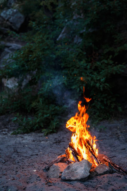 Bonfire on the beach at sunset. Bonfire on the sandy beach. Fire on the beach. Lonely fire on the seashore in autumn