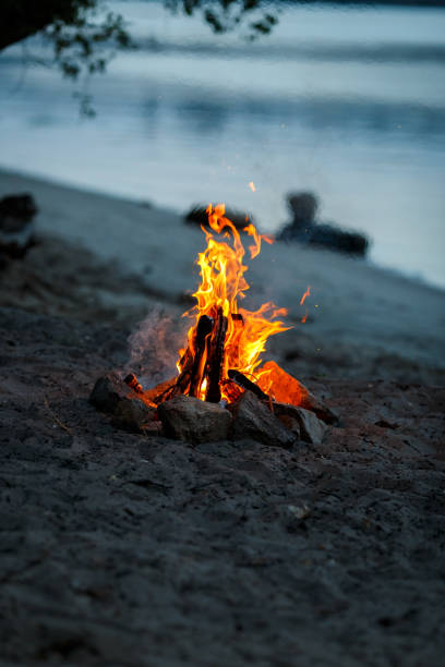 Bonfire on the beach at sunset. Bonfire on the sandy beach. Fire on the beach. Lonely fire on the seashore in autumn