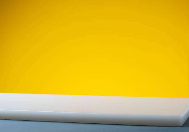 istock Empty white table top, counter, desk background over yellow background, food, product display mockup, template 1172444330