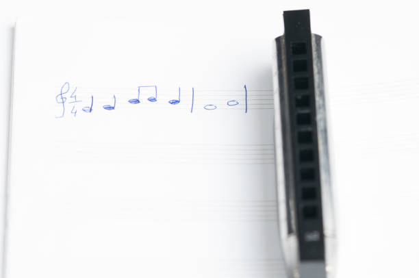 The harmonica lies on a mirrored surface. Classical musical wind instrument.