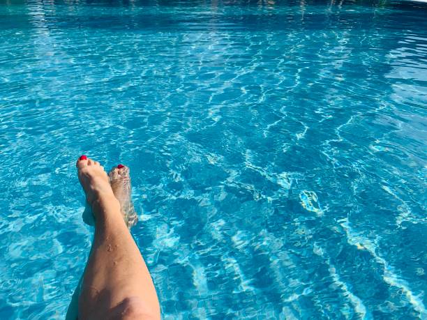 Female legs in the swimming pool