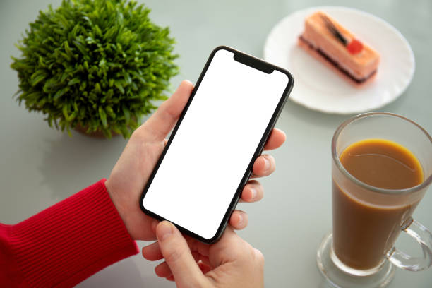 istock female hands holding phone with isolated screen in a cafe 1172450478