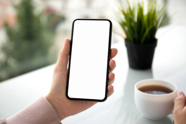 istock female hands holding phone with isolated screen in summer cafe 1172450775