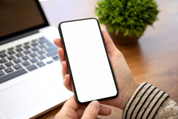 istock female hands holding phone with isolated screen in the office 1172450973