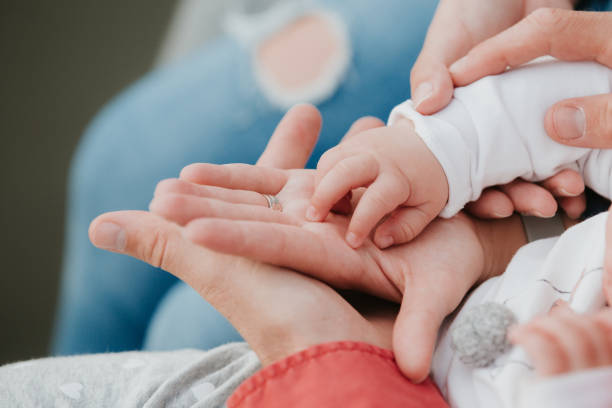 istock Mom and Dad hold baby's hand. Children's handle 1172452003