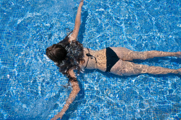 istock Bikini girl swimming in tiles blue pool 1172452936